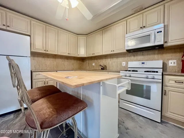 a kitchen with stainless steel appliances a stove a sink a microwave a refrigerator and cabinets