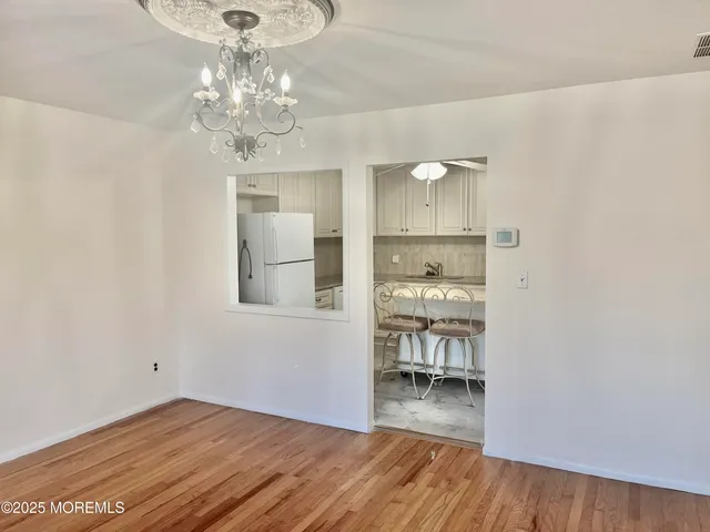 a room with wooden floor and a chandelier