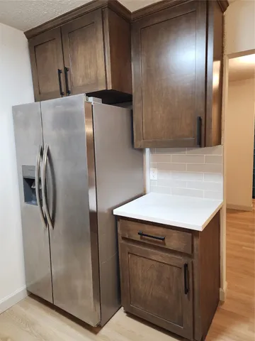 a kitchen with metallic refrigerator freezer and a dishwasher