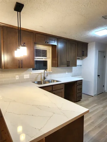 a large kitchen with stainless steel appliances a large counter top