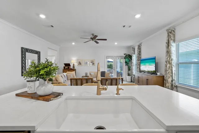 a living room with furniture a chandelier and a flat screen tv