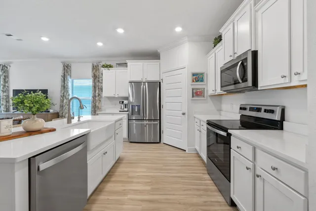 a kitchen with stainless steel appliances granite countertop a refrigerator a stove top oven a sink and dishwasher