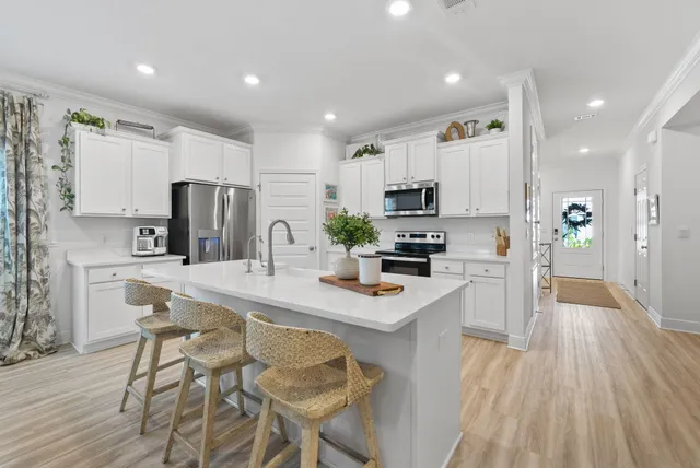 a kitchen with kitchen island white cabinets and stainless steel appliances
