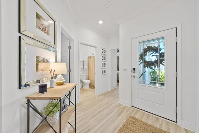 a view of a hallway to a livingroom with furniture wooden floor and windows