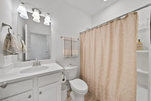 a bathroom with a sink a mirror a toilet and a large mirror