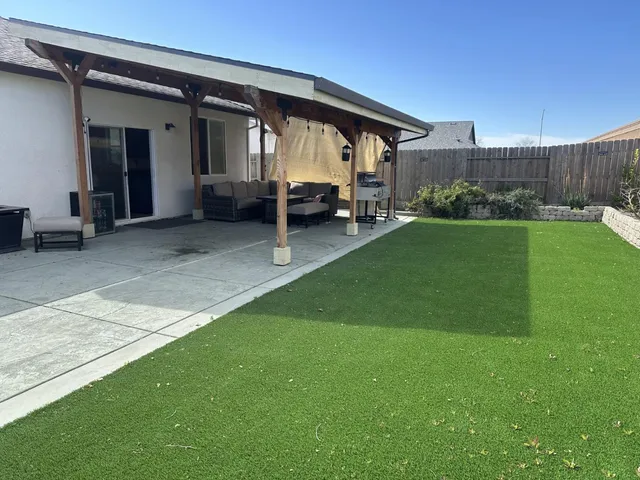 a view of a house with backyard and porch