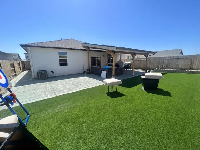 a view of a house with backyard sitting area and fire pit