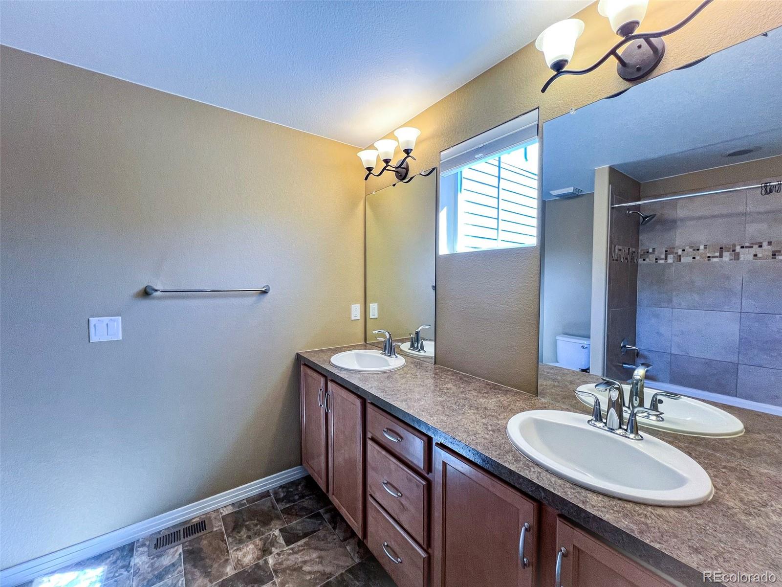 1524 Renaissance Drive Longmont, CO 80503 - Photo 18 of 23 a bathroom with a granite countertop sink and a mirror