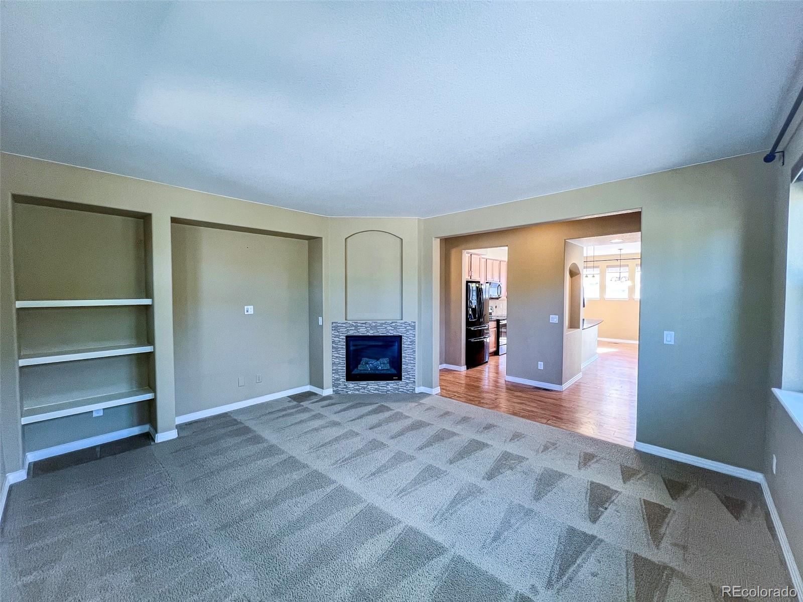 1524 Renaissance Drive Longmont, CO 80503 - Photo 5 of 23 a view of an empty room with a fireplace and a window