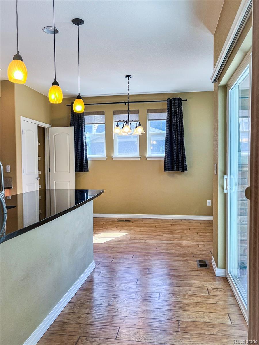 1524 Renaissance Drive Longmont, CO 80503 - Photo 6 of 23 a kitchen with stainless steel appliances granite countertop a refrigerator a stove and a wooden floors