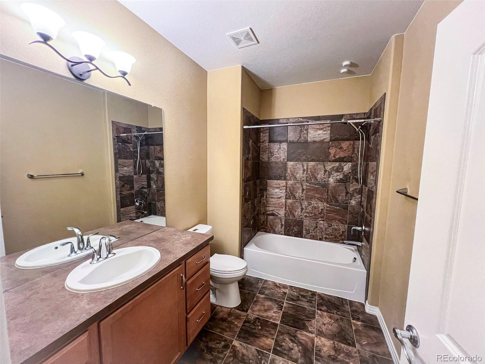 1524 Renaissance Drive Longmont, CO 80503 - Photo 9 of 23 a bathroom with a sink a toilet a mirror a bathtub and shower