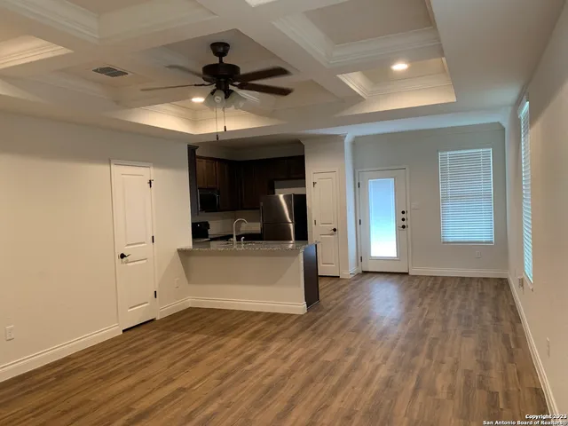 a view of a room with wooden floor and a ceiling fan