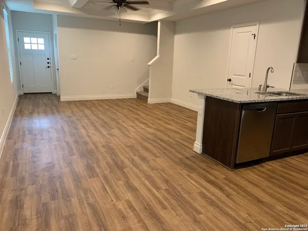 a kitchen with a sink and wooden floor