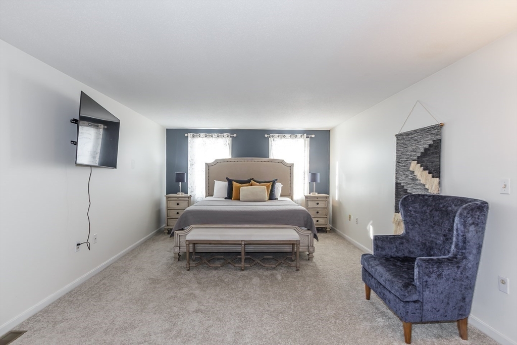 979 Hildreth Street Dracut, MA 01826 - Photo 31 of 39 a spacious bedroom with a bed and a couch