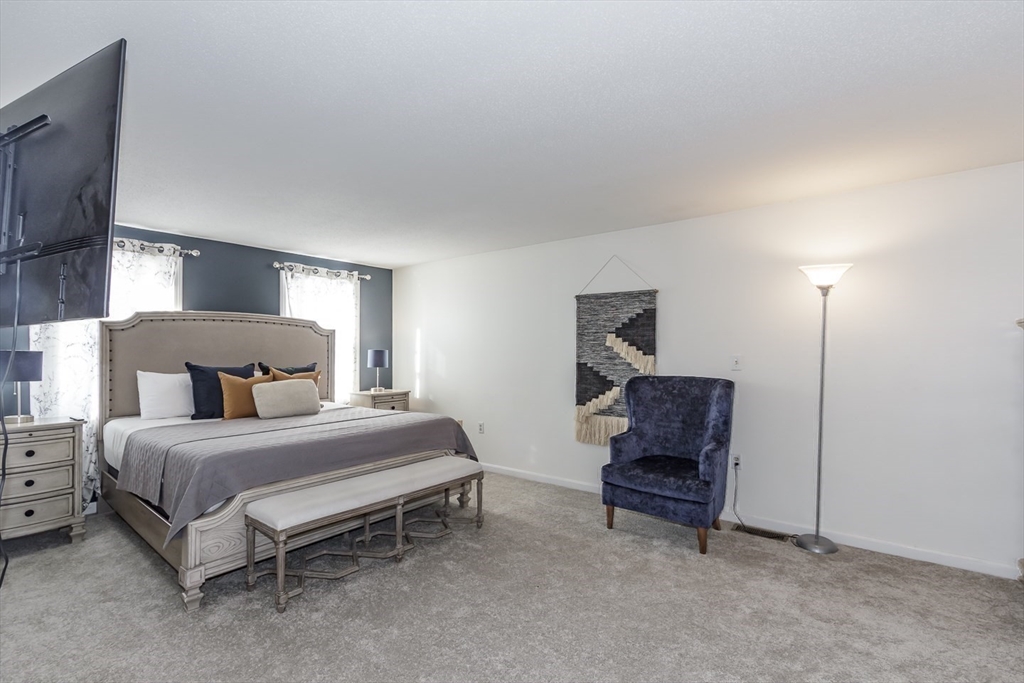 979 Hildreth Street Dracut, MA 01826 - Photo 32 of 39 a bedroom with a bed and a chair