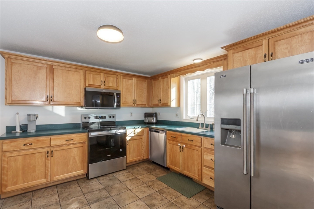 979 Hildreth Street Dracut, MA 01826 - Photo 9 of 39 a kitchen with stainless steel appliances granite countertop a stove a sink and a refrigerator