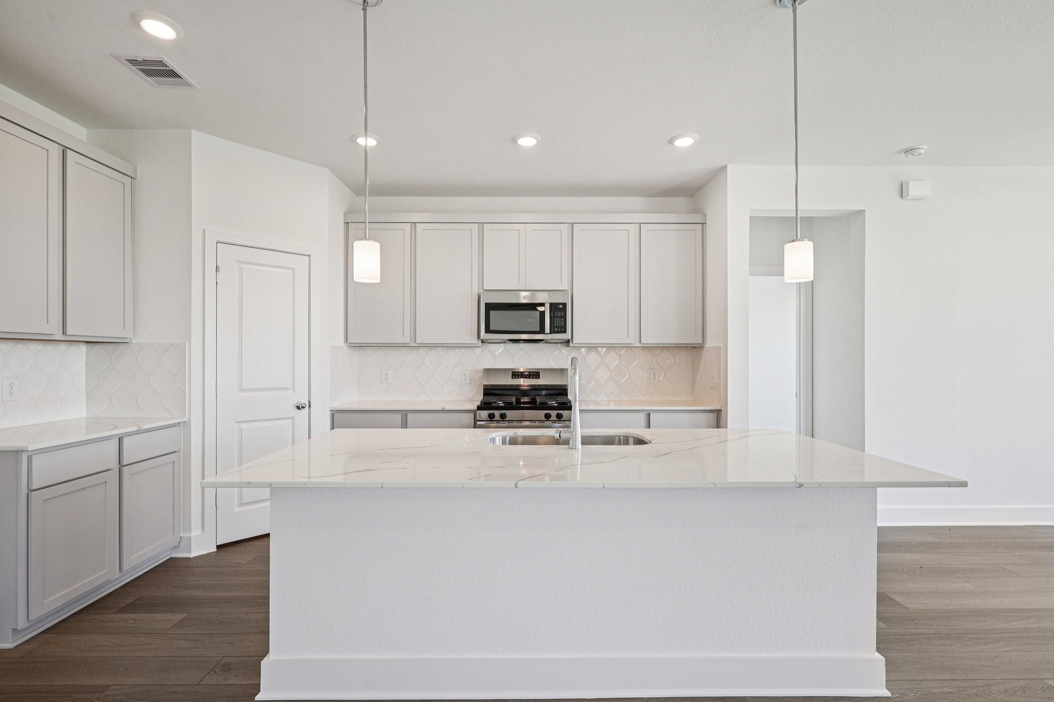 14465 Trumpet Lane Splendora, TX 77372 - Photo 7 of 12 a kitchen with kitchen island white cabinets and stainless steel appliances