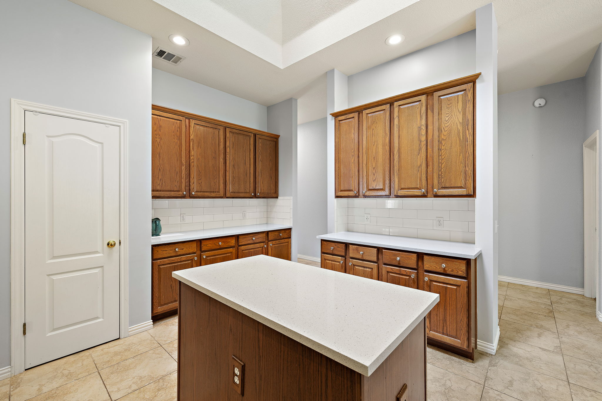 1102 Nelson Ranch Road Cedar Park, TX 78613 - Photo 14 of 37 A central island anchors this naturally illuminated kitchen, featuring generous cabinetry and crisp subway tile backsplash.