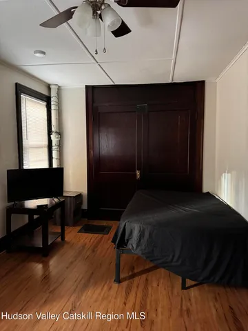a bedroom with a bed and wooden floor