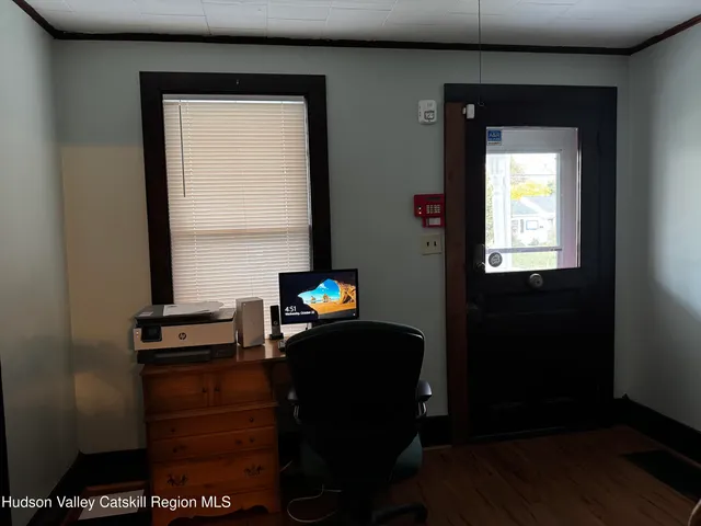 a view of a workspace room with wooden floor and windows