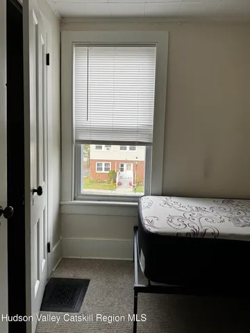 a bed sitting in a bedroom next to a window