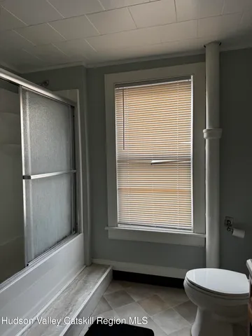 a bathroom with a window and a toilet