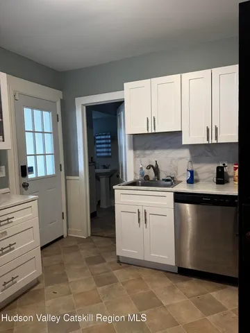 a kitchen with granite countertop white cabinets and white appliances