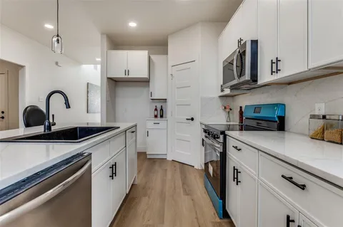 a kitchen with stainless steel appliances granite countertop a sink a stove and a refrigerator