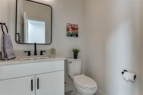 a bathroom with a toilet a sink and mirror