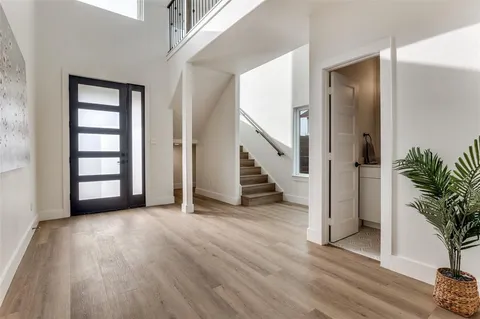 an empty room with wooden floor and stairs