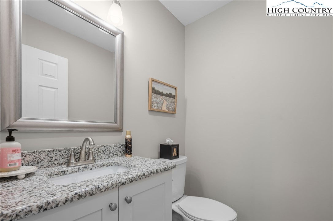 196 Miller Mdw Lane, Unit 38 Boone, NC 28607 - Photo 16 of 32 a bathroom with a granite countertop toilet sink and mirror