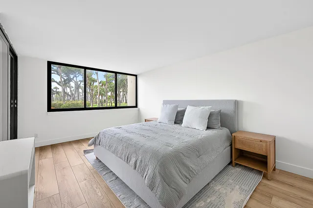 a bedroom with a bed and a large window