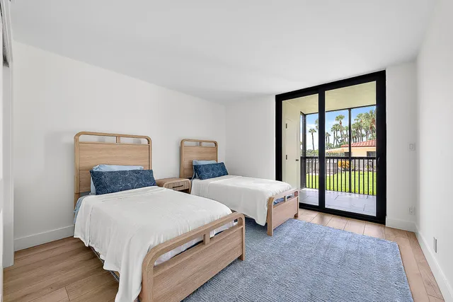 a spacious bedroom with two beds and wooden floor