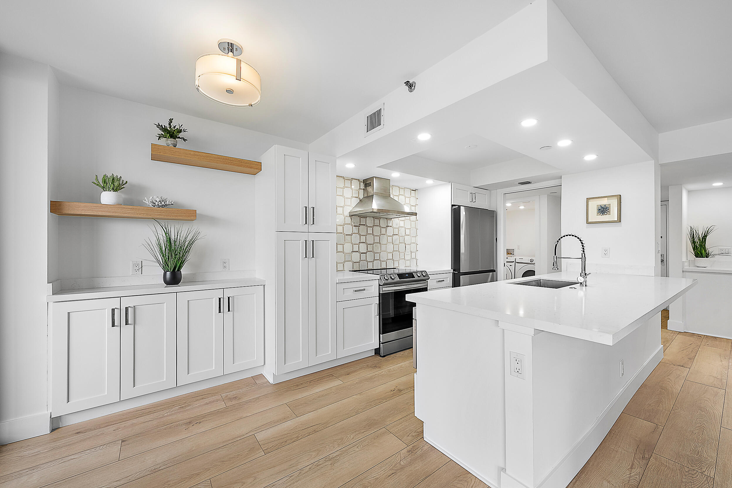 Undisclosed Address Jupiter, FL 33477 - Photo 2 of 28 a large white kitchen with lots of counter space wooden floor and appliances