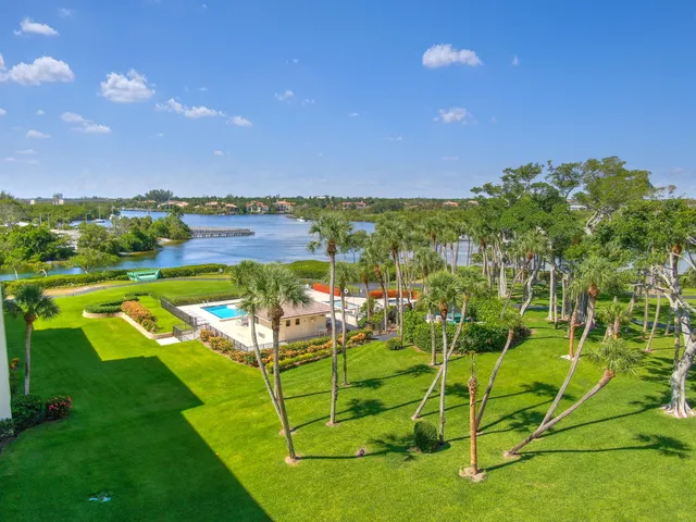 an aerial view of ocean and residential houses with outdoor space