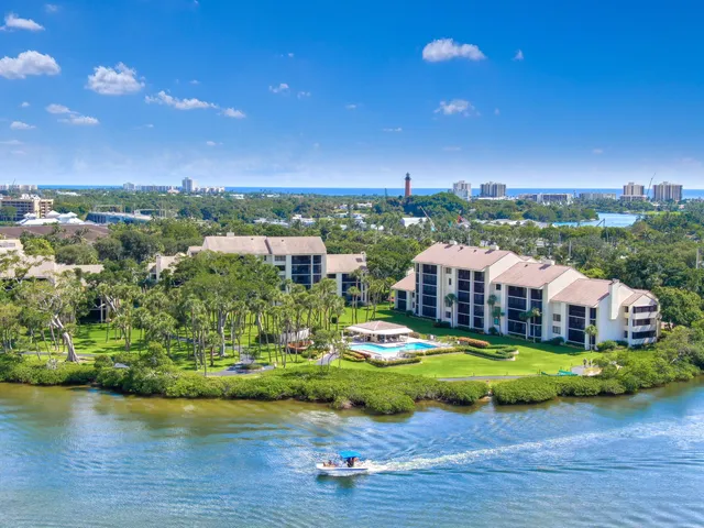 an aerial view of a house with a garden and lake view