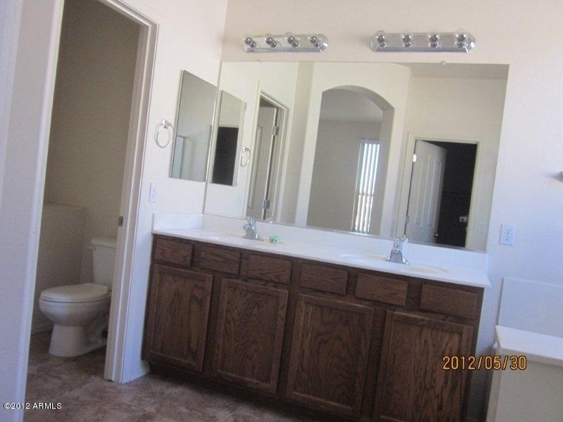 10213 West Payson Road Tolleson, AZ 85353 - Photo 11 of 24 a spacious bathroom with a double vanity sink and a mirror