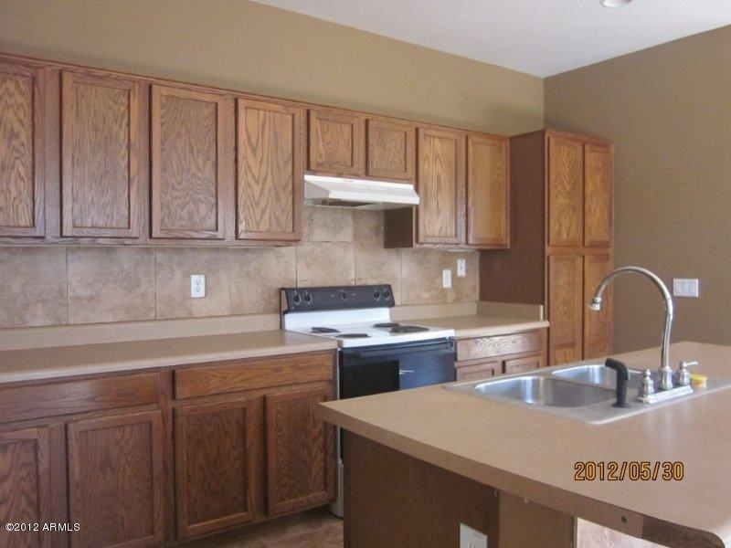 10213 West Payson Road Tolleson, AZ 85353 - Photo 5 of 24 a kitchen with stainless steel appliances granite countertop a sink stove and cabinets