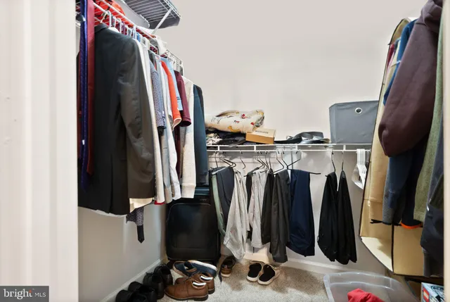a view of walk in closet with clothes and shoes