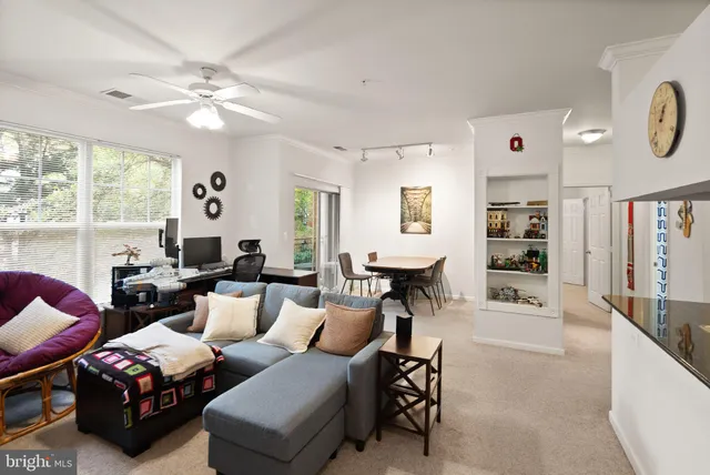 a living room with furniture a large window and a chandelier