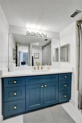 a kitchen with kitchen island granite countertop a sink and a stove top oven