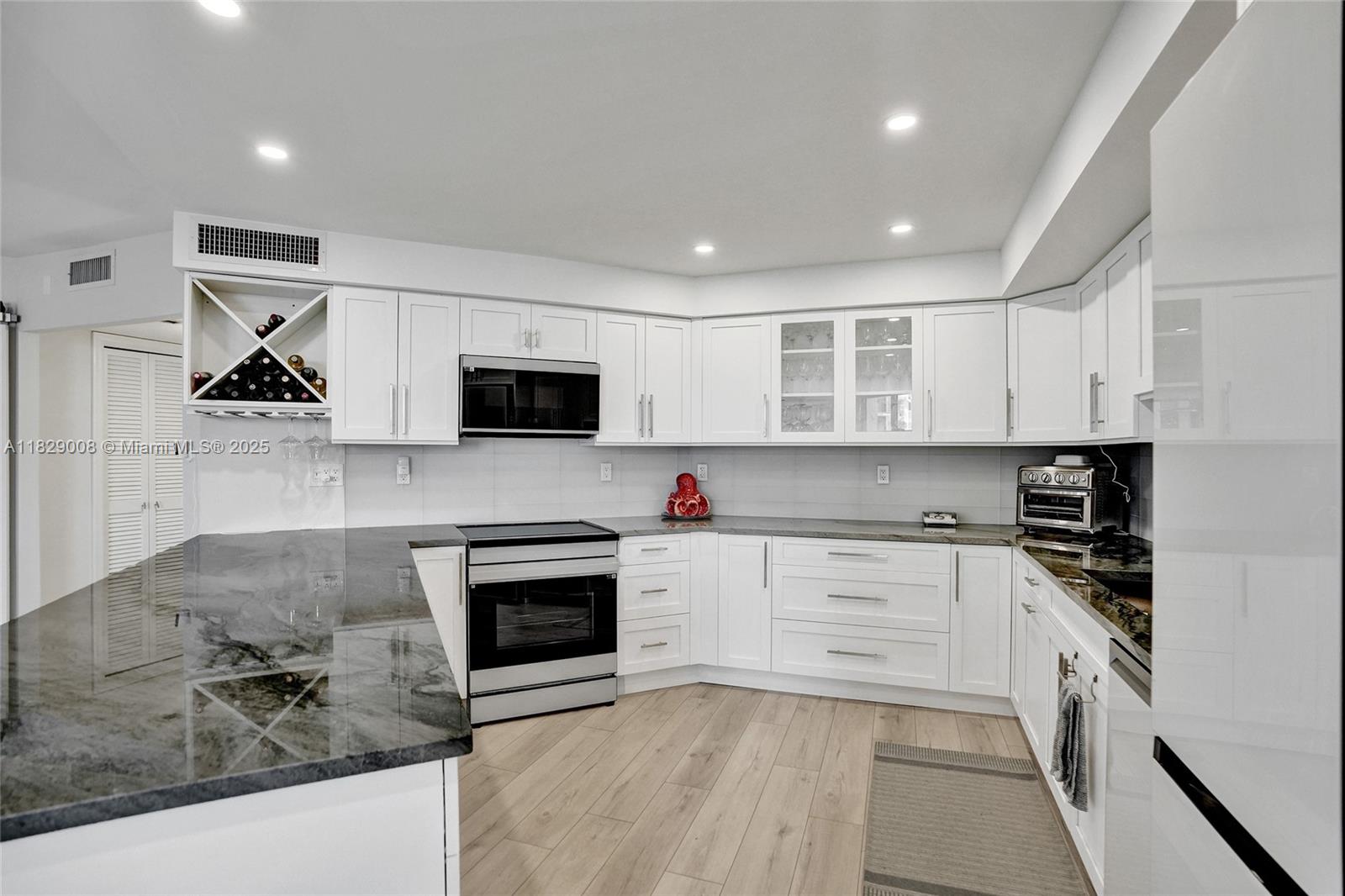 1340 South Ocean Boulevard, Unit 403 Pompano Beach, FL 33062 - Photo 30 of 74 a kitchen with granite countertop white cabinets and appliances