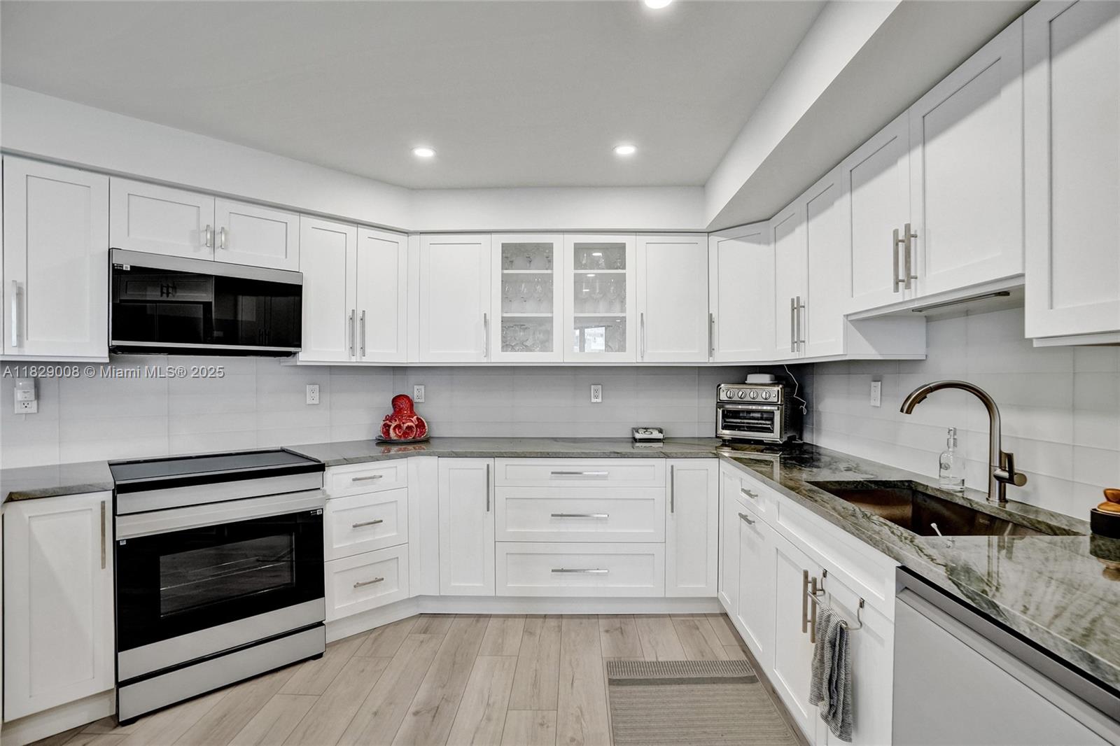 1340 South Ocean Boulevard, Unit 403 Pompano Beach, FL 33062 - Photo 32 of 74 a kitchen with cabinets stainless steel appliances a sink and a counter space