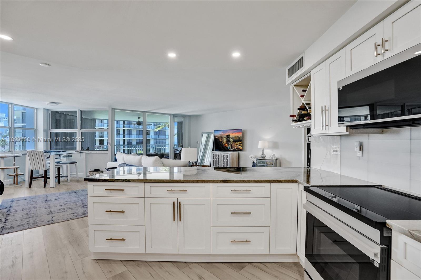 1340 South Ocean Boulevard, Unit 403 Pompano Beach, FL 33062 - Photo 36 of 74 a kitchen with kitchen island granite countertop a sink and a stove top oven