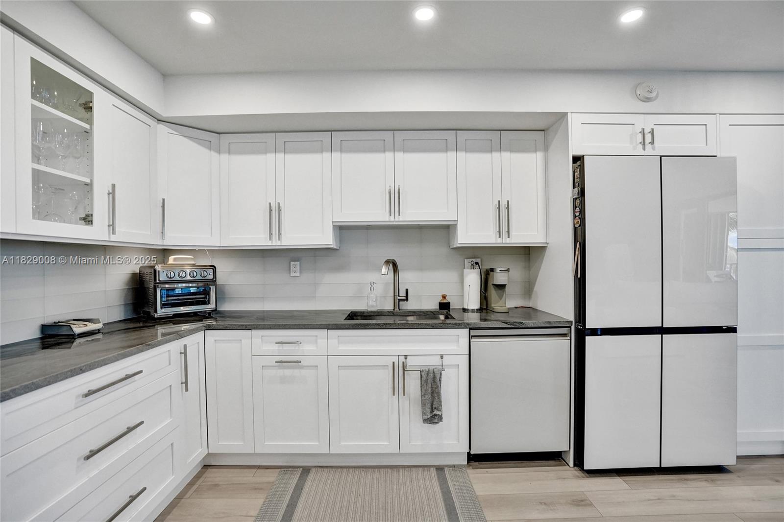 1340 South Ocean Boulevard, Unit 403 Pompano Beach, FL 33062 - Photo 37 of 74 a kitchen with granite countertop white cabinets and white appliances