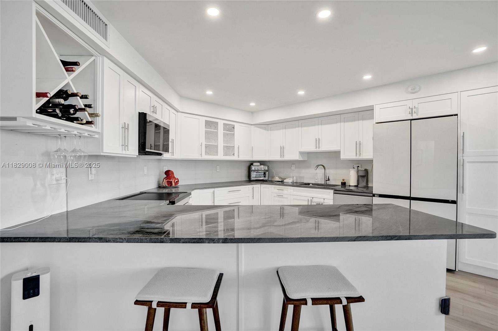 1340 South Ocean Boulevard, Unit 403 Pompano Beach, FL 33062 - Photo 7 of 74 a kitchen with stainless steel appliances granite countertop a sink a stove a microwave a refrigerator and white cabinets
