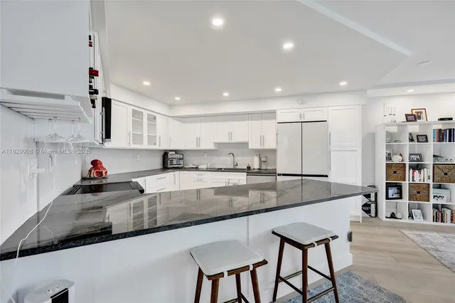 a living room with furniture and view of kitchen