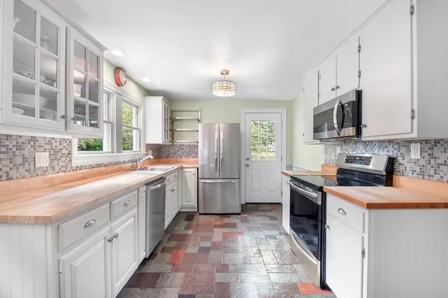 a kitchen with stainless steel appliances granite countertop a stove a sink and a refrigerator