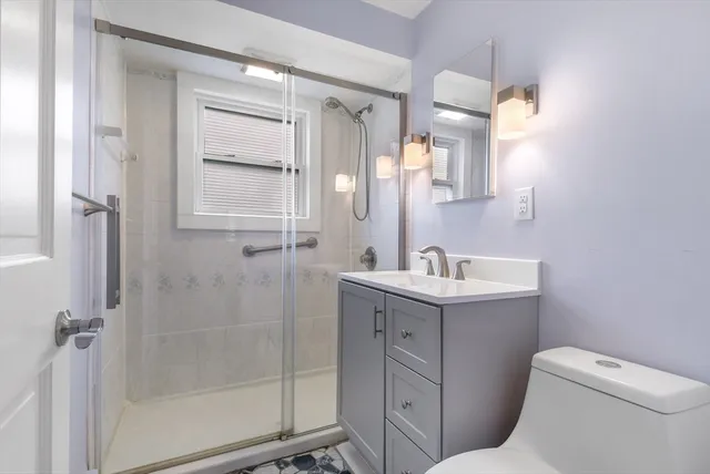 a bathroom with a sink a toilet and shower