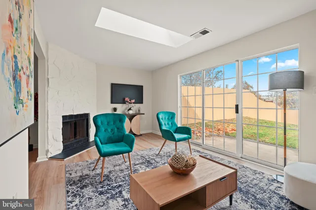 a living room with furniture a flat screen tv and a large window